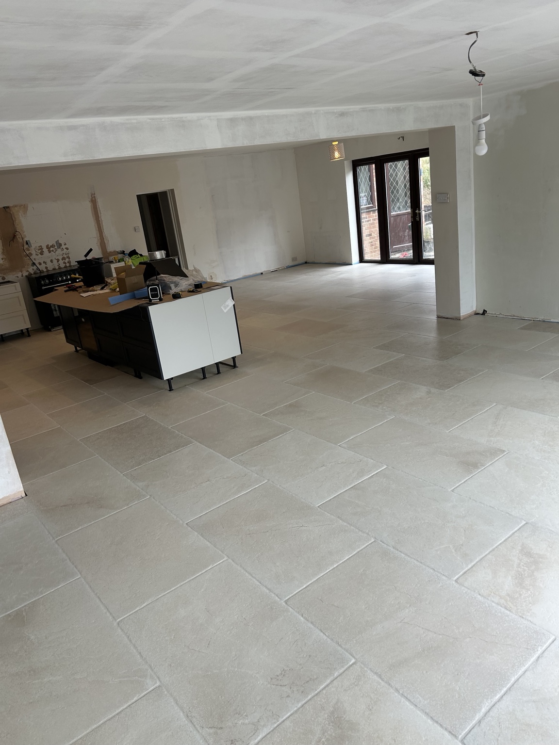 Large open-plan floor finished in light stone-effect tiles
