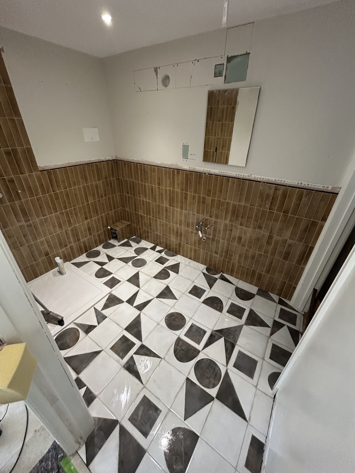 Bathroom with warm wall tiles and a bold patterned floor