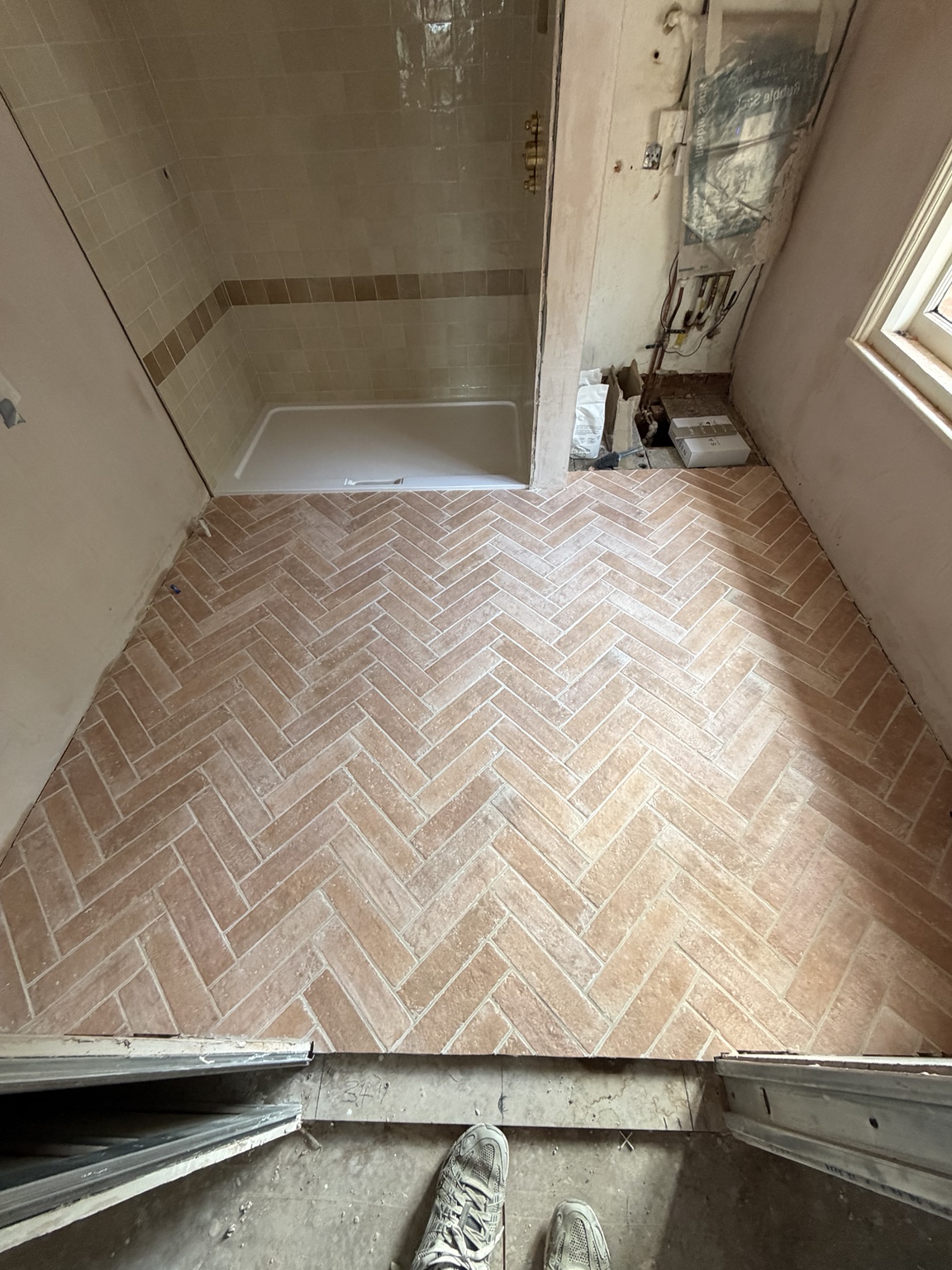 Warm natural stone tiles laid in a herringbone pattern
